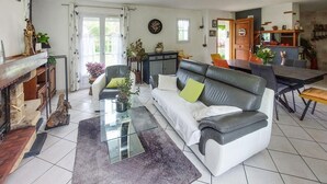 A living room with a sofa, coffee table, and a dining area with a table and chairs.