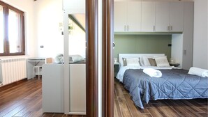 Un dormitorio con cama, armario y escritorio.