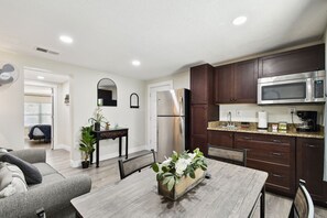 A modern kitchen with dark wooden cabinets, a stainless steel refrigerator, and a built-in microwave.
