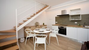 Eine moderne Küche mit weißen Schränken, einer Holzarbeitsplatte und einem eingebauten Backofen.