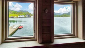 A window with a view of a lake, dock, and houses across the water. - 2 bedroom lovely home in Erfjord (Erfjord)