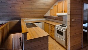 A compact kitchen with wooden cabinetry, a built-in sink, and a stove. - 2 bedroom lovely home in Erfjord (Erfjord)