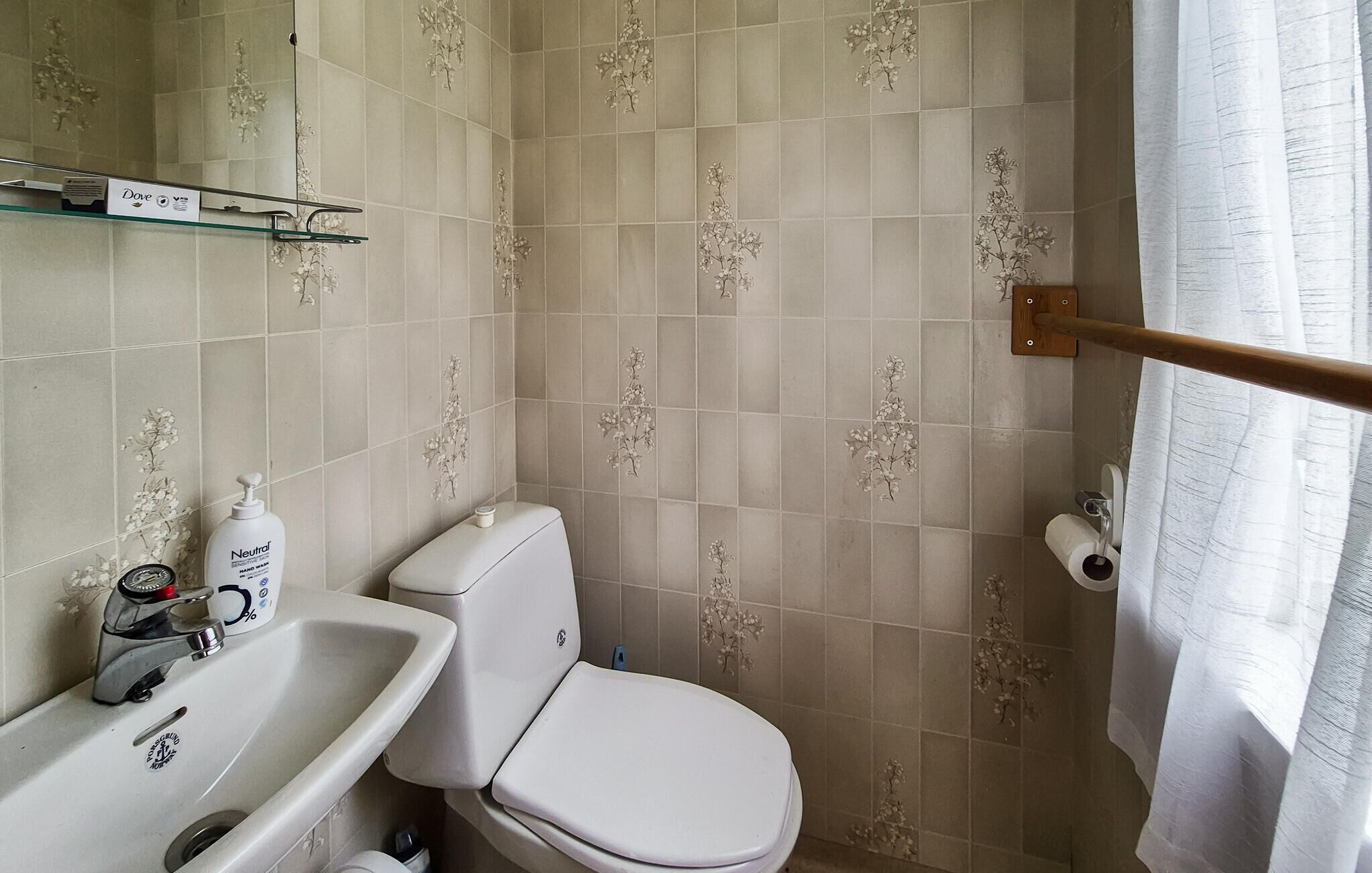 A bathroom with a toilet, sink, and shower curtain.