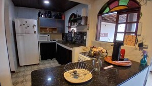 Une cuisine équipée d’un réfrigérateur, d’un four à micro-ondes, d’une cuisinière et d’une fenêtre sur laquelle est affiché un panneau indiquant « HÔTEL ».