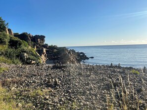 Une plage de galets sous un ciel dégagé.