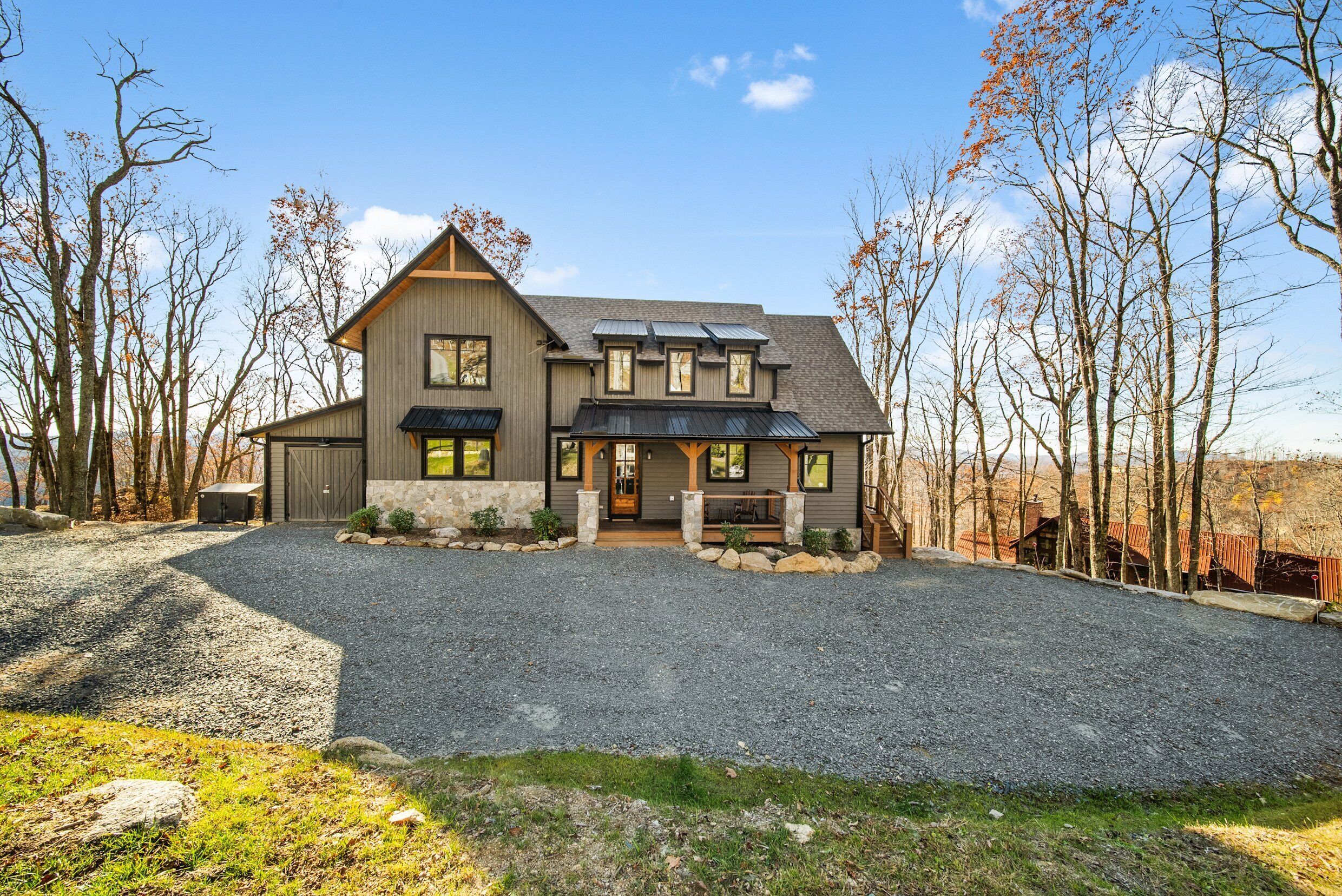 Une maison à deux étages avec une allée en gravier, un porche avant couvert et un grand garage.