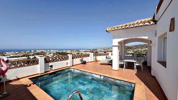 A rooftop pool with a view of the sea, a white building with a tiled roof, and a flamingo statue. - AP418 VILLA MARIVI (Torrox)