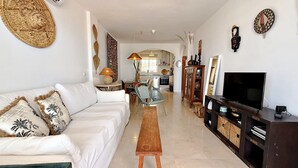 A living room with a sofa, coffee table, TV stand, and decorative items. - AP418 VILLA MARIVI (Torrox)