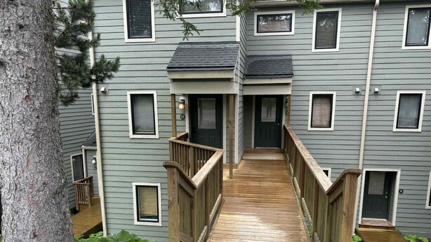 A multi-story building with a central staircase leading to a landing. - Powderidge 15 Slope Side (Snowshoe)