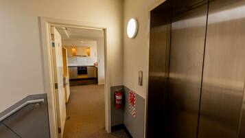 A hallway with a door leading to a kitchen area.