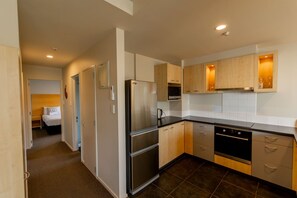 Cocina compacta con refrigerador, horno y lavavajillas.