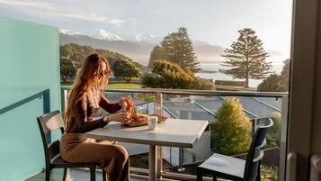 A person seated at a table with a view of mountains and trees.