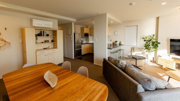 A modern living space with a dining area, kitchen, and seating area.