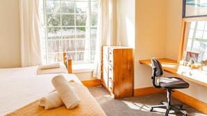Een hotelkamer met een bed, een bureau en een raam.