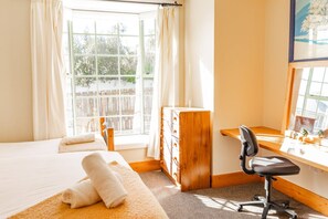 Una habitación de hotel con una cama, un escritorio y un ventanal.