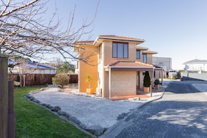 Une maison d’habitation à deux étages, dotée d’un garage, d’une allée et d’une pelouse bien entretenue.
