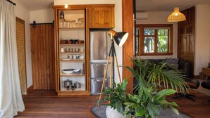 A kitchen with wooden cabinets, a stainless steel refrigerator, and a floor lamp. - Kowhai Cottage | Pizza Oven | Super Central - KK32726 (Kaikoura)