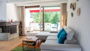 Una sala de estar moderna con chimenea, un sofá y vistas al exterior.