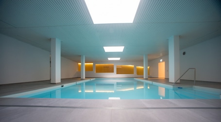 Indoor pool, a heated pool. Apartment with fireplace, pool, and sauna
