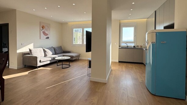 Eine moderne Wohnung mit Wohnzimmer, Küche und Essbereich.