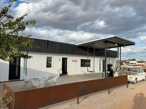 A building with a covered outdoor area, a car, and a sign that reads "PIK-PAK". - Pik-Pak D - "Tuff’s Place" (Marfa)