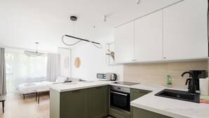 Een moderne keuken met een centraal eiland, inbouwoven, magnetron en spoelbak.