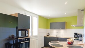 Een moderne keuken met een Bosch magnetron, een koffieapparaat en een spoelbak.