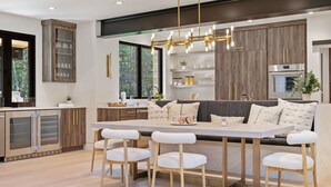A modern kitchen with a central island, bar stools, and built-in cabinets. - RMR: Tensleep Oasis Home in The Aspens/Wilson,WY (Wilson)