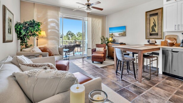 A spacious living area with a sofa, a dining table, and a kitchen area with a dishwasher.