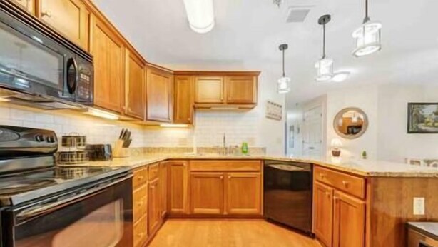 A kitchen with wooden cabinets, a stainless steel oven, and a dishwasher. - Spacious 1 king bedroom WiFi on-site restaurant (Moneta)