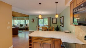 A kitchen with wooden cabinets, a granite countertop, and pendant lighting. - Dog Friendly Condo at Clearbrook (Lincoln)
