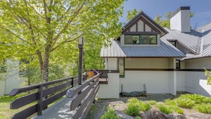 A modern house with a wooden deck, a stone pathway, and a well-maintained garden.