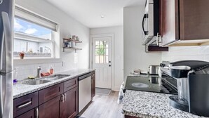 Una cocina con encimeras de granito, electrodomésticos de acero inoxidable y armarios de madera.