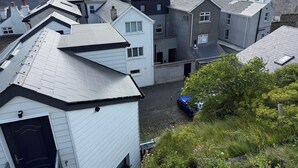 A residential area with multiple houses, a clear view of the sea, and a parking area. - Modern Split-Level 2-Bed Apartment with Balcony (Causeway Coast and Glens)