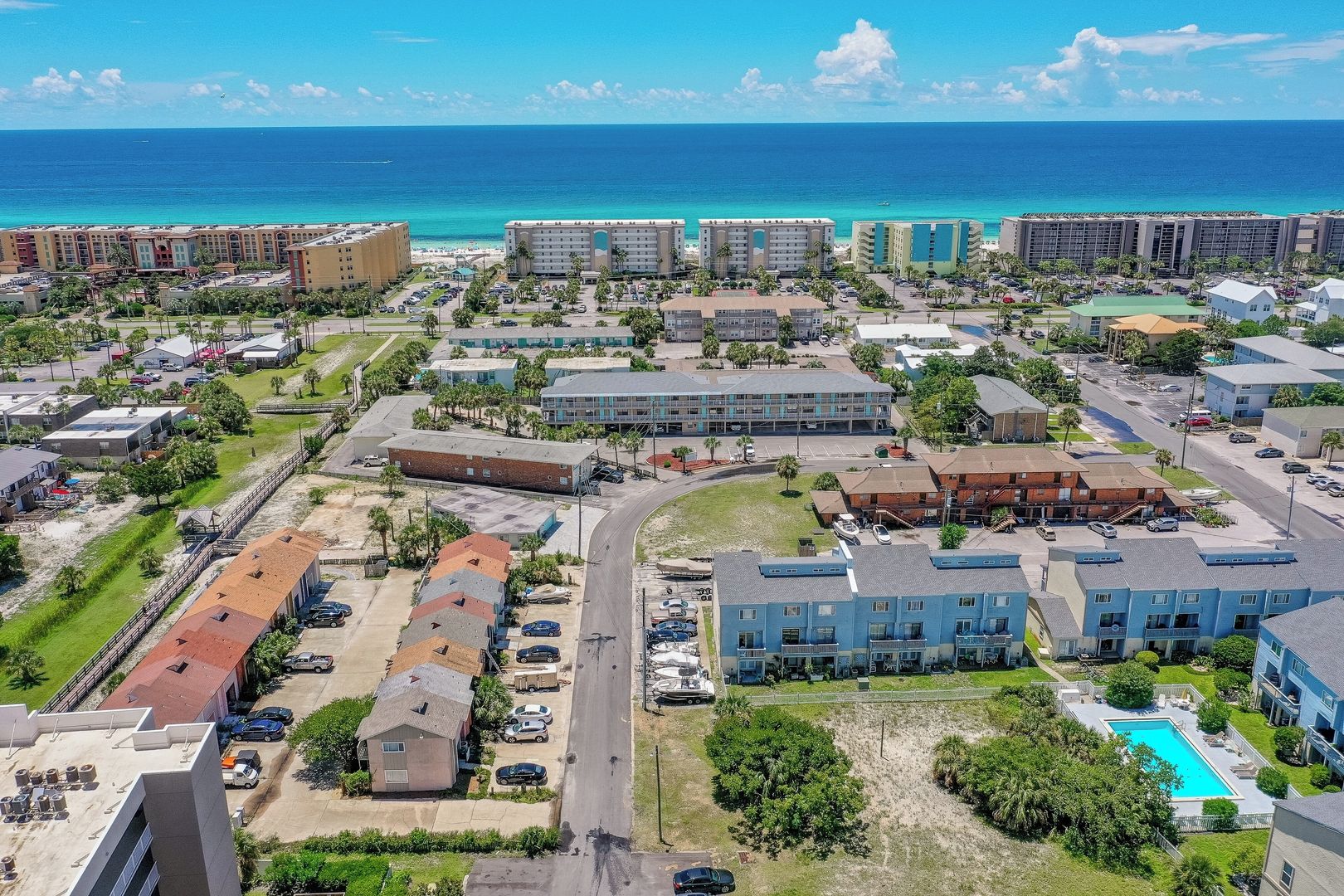 Un complexe hôtelier situé sur la côte, composé de plusieurs bâtiments, doté d’une piscine et offrant une vue sur l’océan.