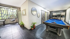 A modern indoor pool area with a pool table, seating, and potted plants. - 6 Bedoom Apartment with Balcony, Pool tableJacuzzi (Medellín)
