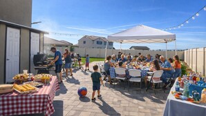 An outdoor gathering with a barbecue, tables with food, and a tent. - 4-bedroom house in wonderful Perris with WiFi, AC (Perris)