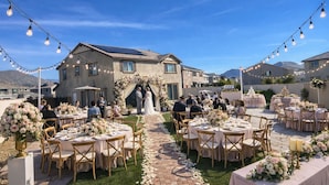 An outdoor wedding venue with tables, chairs, and a decorated archway. - 4-bedroom house in wonderful Perris with WiFi, AC (Perris)