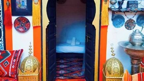 A room with a central archway leading to a bed, surrounded by vibrant decor and traditional furnishings. - Authentic Riad in Marrakech - A Living Museum of Moroccan Art (Marrakech)
