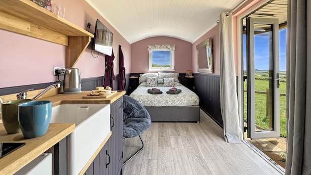 Une chambre à coucher avec un lit, une télévision, une fenêtre et une vue sur l’extérieur.