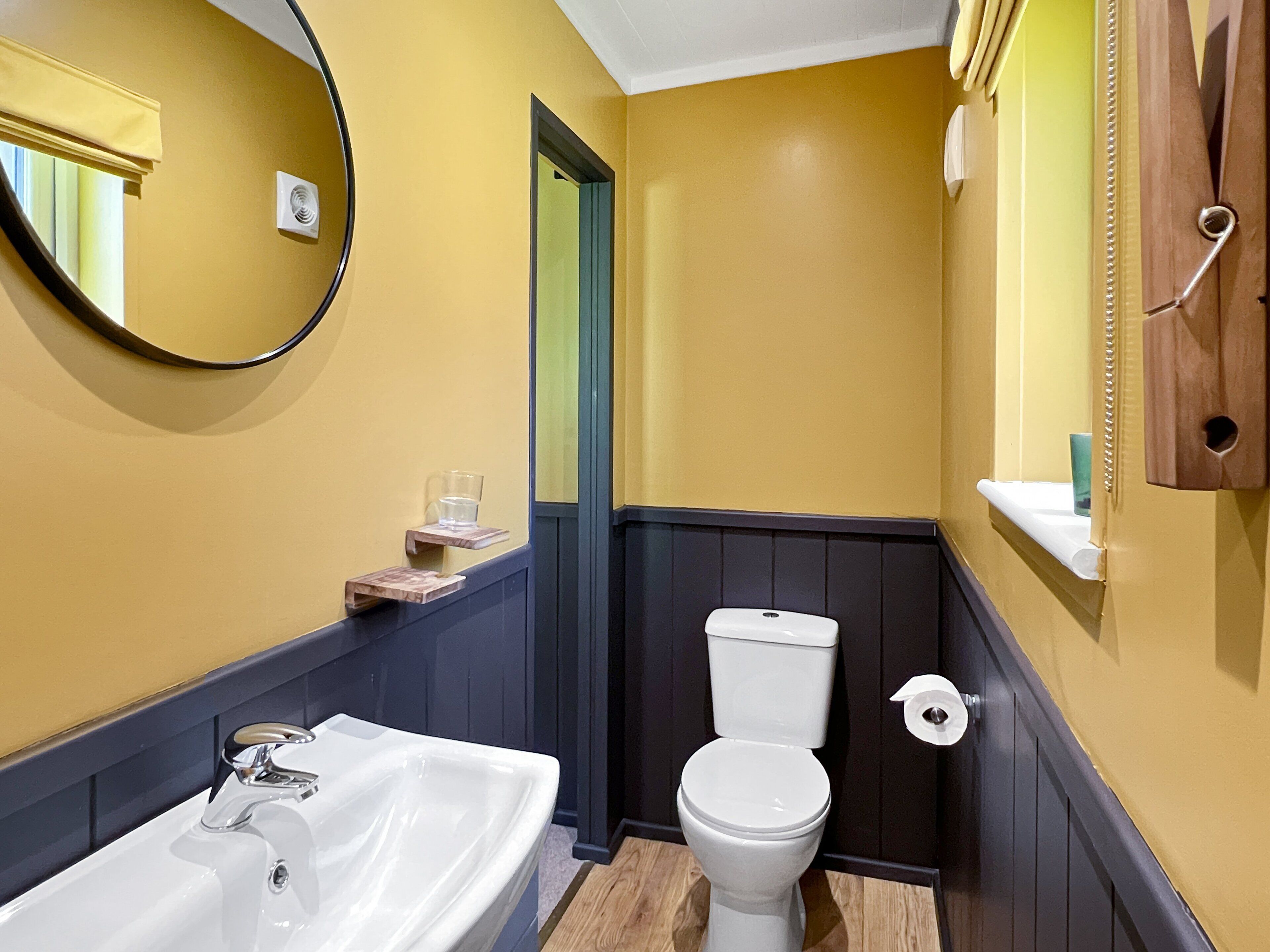 Een badkamer met een wit wastafel, toilet en spiegel.