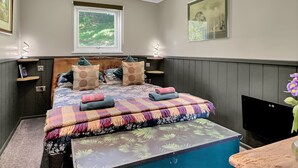 A bedroom with a bed, a window, a painting, and a television. - Robins Nest Lodge, South Molton (South Molton)