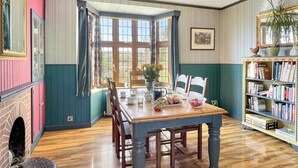 A dining area with a wooden table, chairs, and a bookshelf.