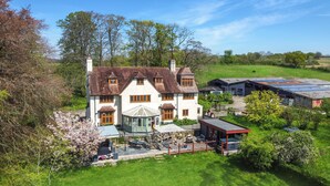 A large house with a garden, a gazebo, and a barn.