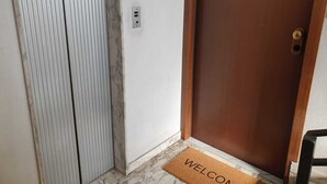 A wooden door with a doormat that reads "WELCOME". - COCO Apartments (Catania)