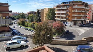 A multi-story residential building with balconies, a parking lot with cars, and a roundabout. - COCO Apartments (Catania)