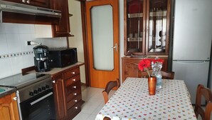 A kitchen with wooden cabinets, a microwave, a coffee maker, and a refrigerator. - COCO Apartments (Catania)