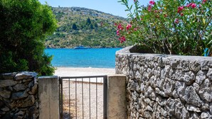 A stone wall with a metal gate leading to a beach. - Cozy home in Rogoznica with WiFi (Rogoznica)