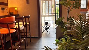 Een hotelkamer met een zithoek, een balkon en uitzicht op de stad.