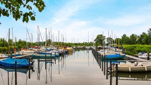 A marina with multiple boats docked and a calm water surface.